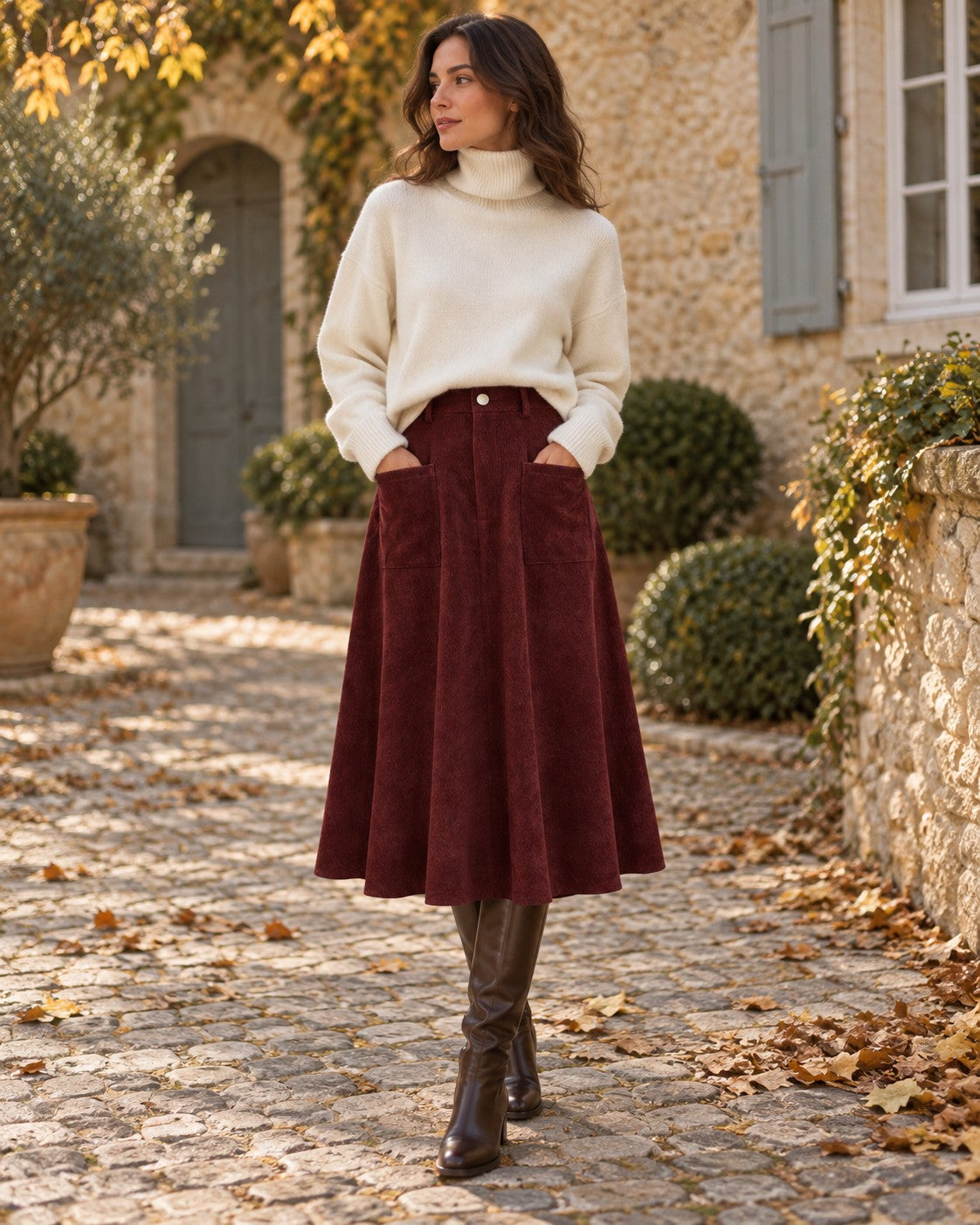 Woman wearing the Burgundy Corduroy Outfit: ivory chunky turtleneck sweater and burgundy corduroy A-line skirt