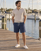 Man wearing the Harbour Linen Outfit: stone ribbed open-collar polo and navy linen shorts
