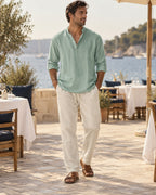 Man wearing the Long Lunch Popover Outfit: sage cotton band-collar popover shirt and sand drawstring trousers
